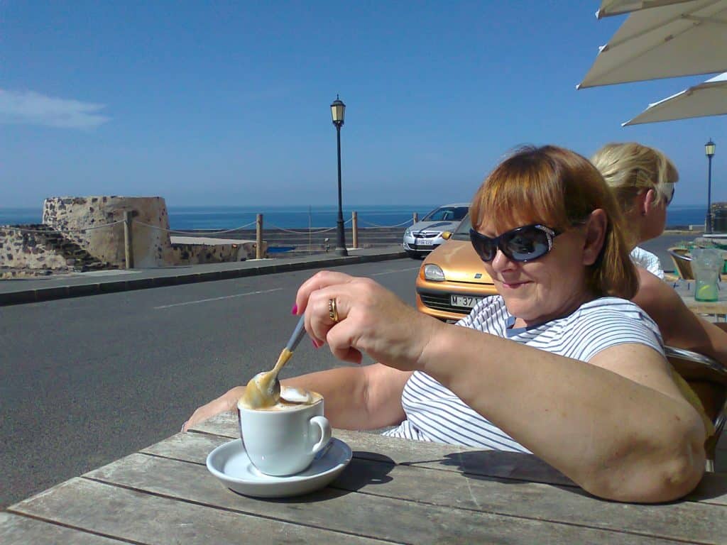 About Us 2 Sue having a coffee on our first day as full time residents of El Cotillo in February 2013
